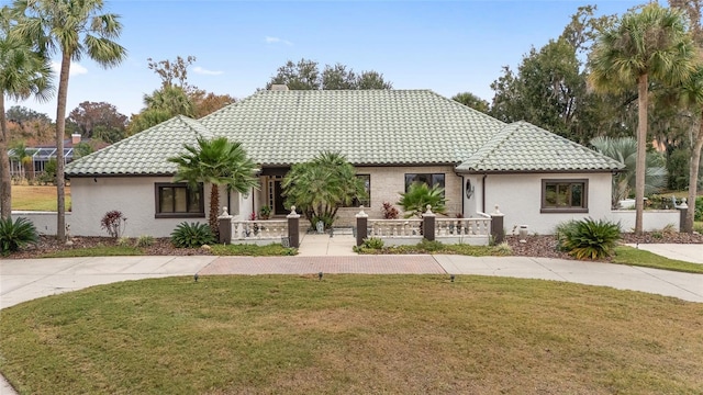 mediterranean / spanish-style house with a porch and a front lawn