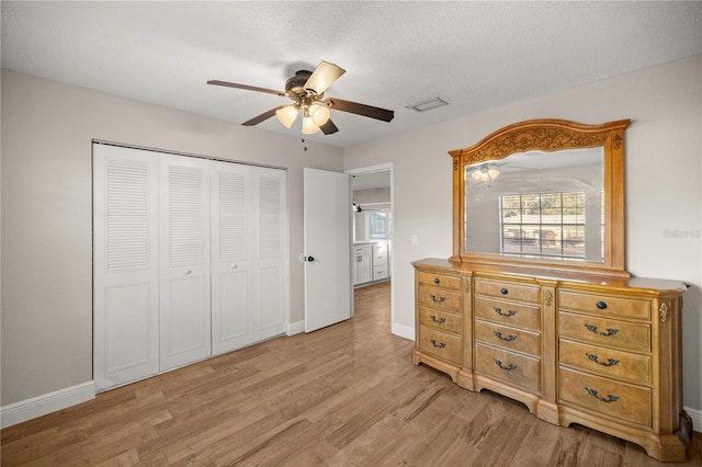 bedroom with ceiling fan, a closet, a textured ceiling, and light wood-type flooring