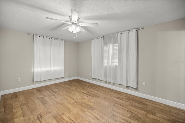 spare room with ceiling fan, light hardwood / wood-style flooring, and a textured ceiling