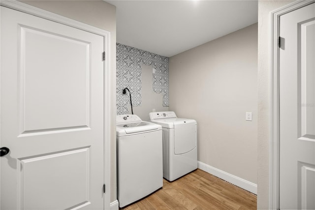 laundry area with light wood-type flooring and washing machine and clothes dryer