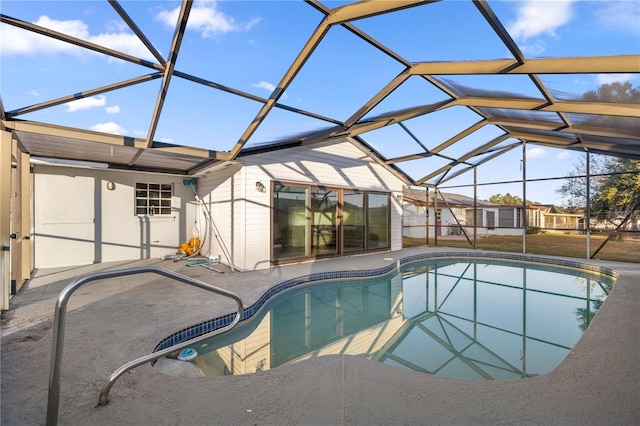 view of pool with glass enclosure and a patio