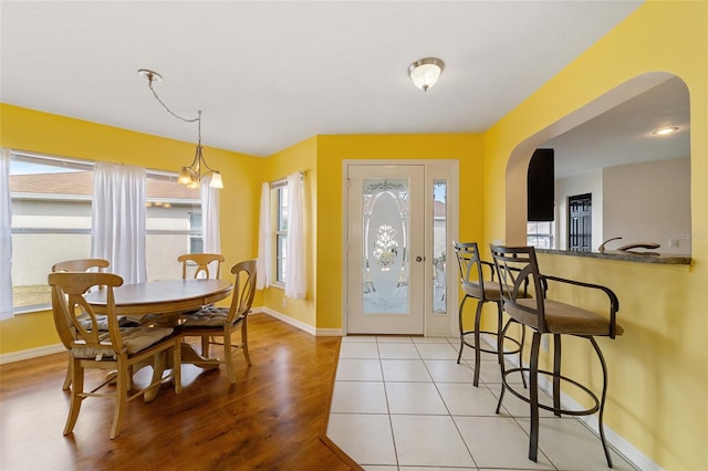 dining room with light hardwood / wood-style floors and a notable chandelier