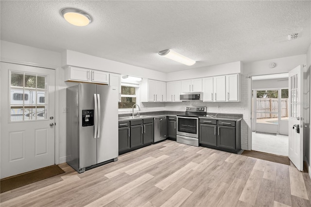 kitchen featuring stainless steel appliances, sink, white cabinets, and gray cabinets