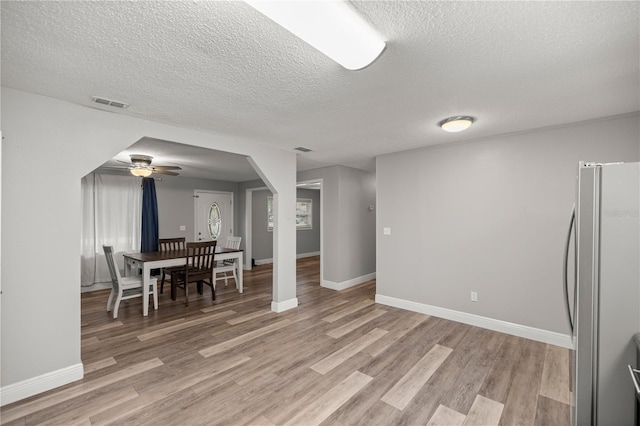 dining room featuring ceiling fan, a textured ceiling, and light hardwood / wood-style floors