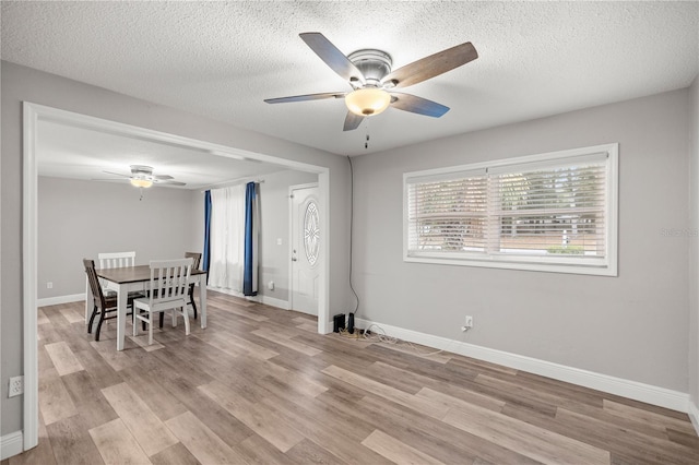 dining area with ceiling fan, a textured ceiling, and light hardwood / wood-style flooring