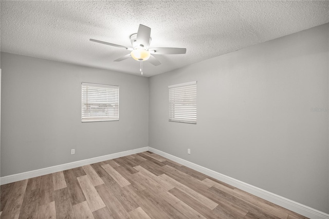 spare room with ceiling fan, light hardwood / wood-style floors, and a textured ceiling