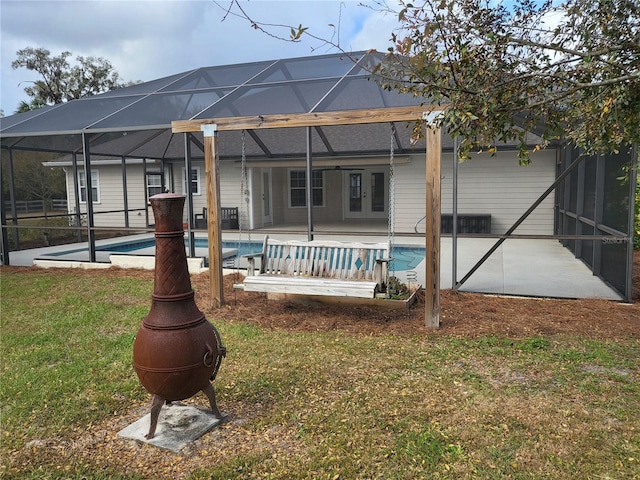 back of house with a yard, a patio, and a lanai