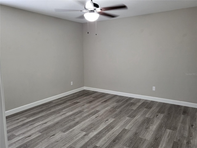 empty room with dark hardwood / wood-style floors and ceiling fan