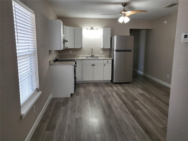 kitchen with ceiling fan, dark wood-type flooring, sink, white cabinetry, and stainless steel refrigerator