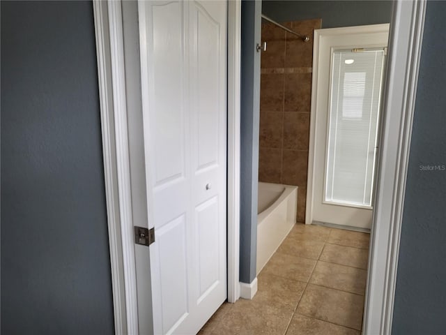 bathroom featuring tiled shower / bath combo and tile patterned floors