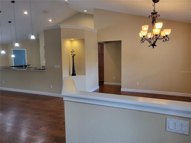 kitchen featuring lofted ceiling, dark wood-type flooring, decorative light fixtures, and an inviting chandelier