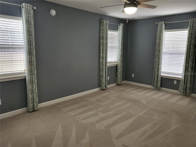 spare room with carpet, ceiling fan, and a wealth of natural light