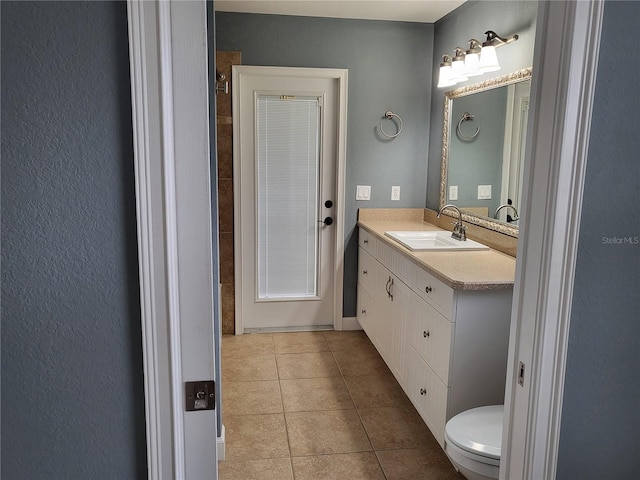 bathroom featuring tile patterned flooring, vanity, and toilet