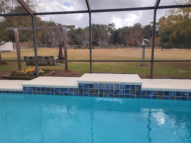 view of swimming pool featuring glass enclosure and a lawn