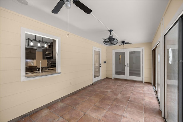 unfurnished sunroom with french doors, ceiling fan, and sink