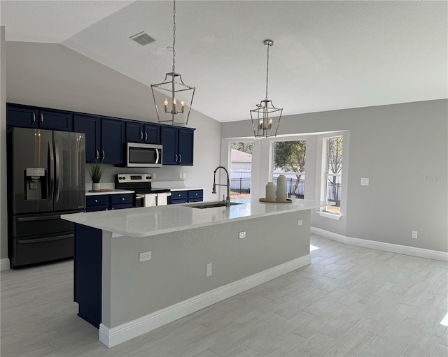 kitchen with stainless steel appliances, vaulted ceiling, and a center island with sink