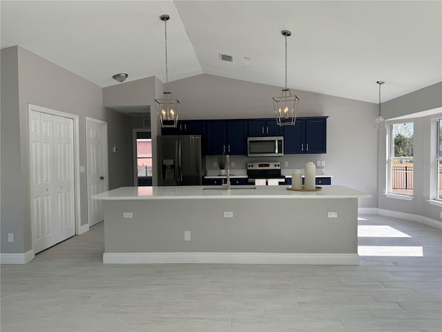 kitchen with a center island with sink, lofted ceiling, stainless steel appliances, and blue cabinetry