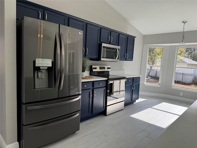 kitchen featuring stainless steel appliances, blue cabinetry, decorative light fixtures, light hardwood / wood-style flooring, and lofted ceiling