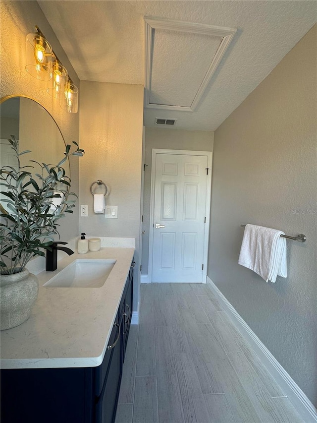 bathroom with vanity, wood-type flooring, and a textured ceiling