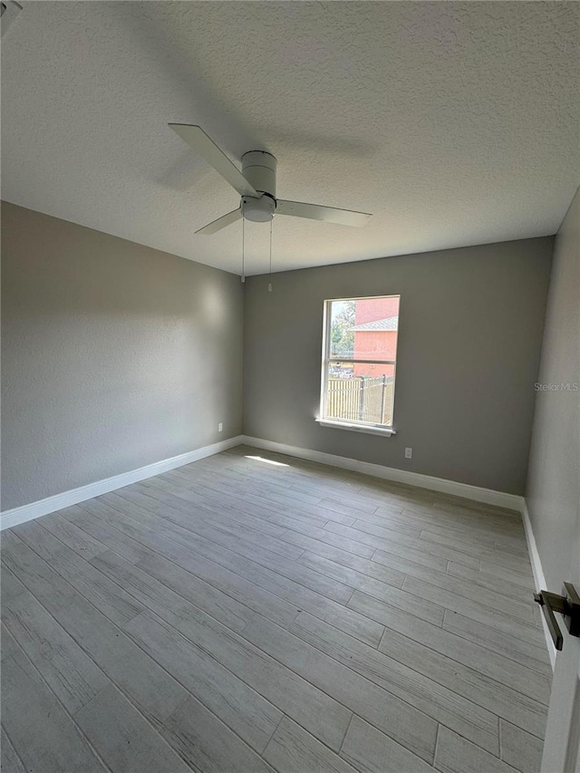 unfurnished room featuring a textured ceiling, light hardwood / wood-style flooring, and ceiling fan