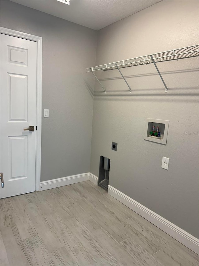 washroom with hookup for a washing machine, light wood-type flooring, and hookup for an electric dryer