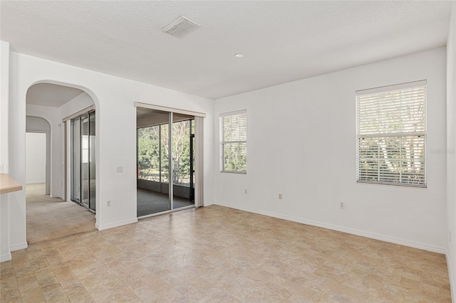 unfurnished room with a textured ceiling