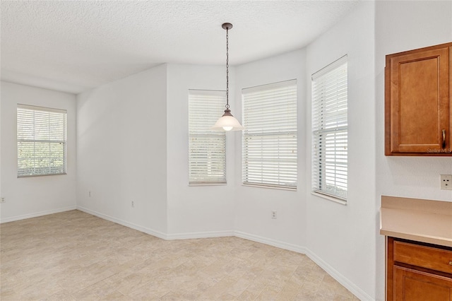 unfurnished dining area with a textured ceiling