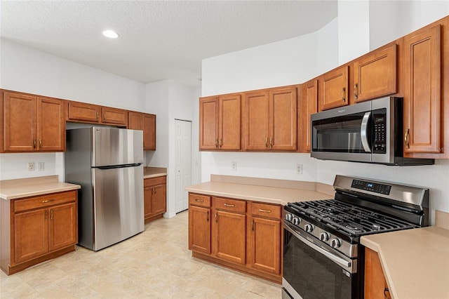 kitchen with a textured ceiling and stainless steel appliances