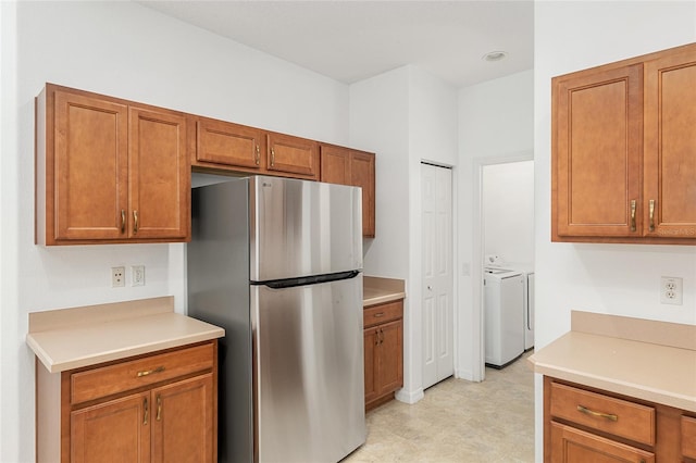 kitchen with stainless steel fridge and independent washer and dryer