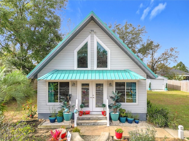 bungalow-style home featuring french doors and a front lawn