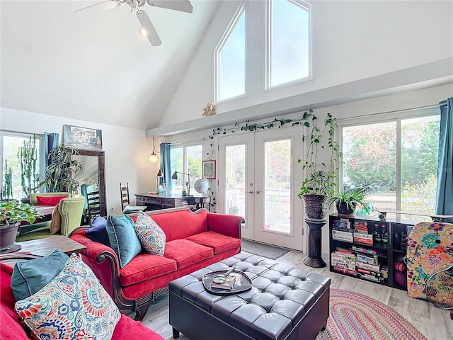 living room with ceiling fan, light hardwood / wood-style floors, high vaulted ceiling, and french doors