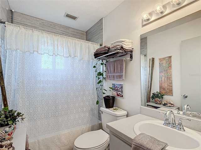 full bathroom featuring shower / bath combo with shower curtain, vanity, and toilet