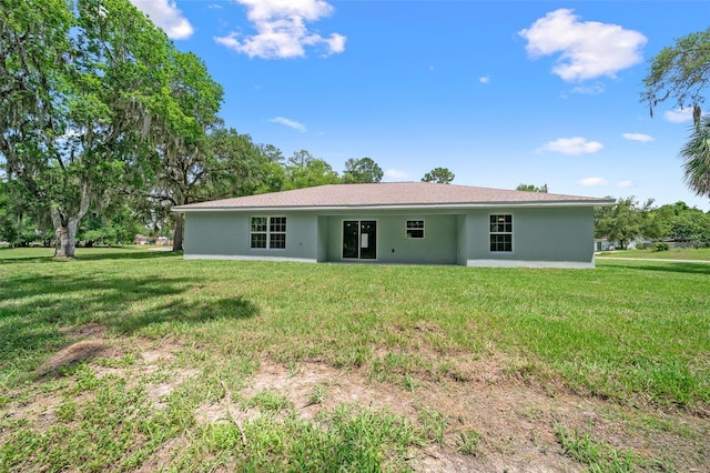 rear view of property with a lawn