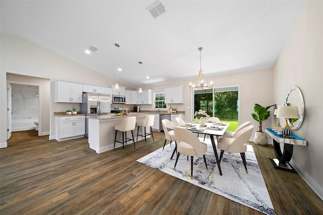 dining room with vaulted ceiling, dark wood-type flooring, and a notable chandelier