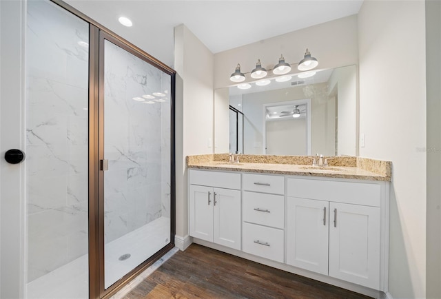 bathroom featuring wood-type flooring, vanity, a shower with door, and ceiling fan