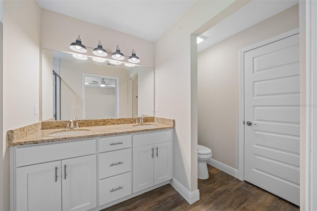 bathroom with ceiling fan, toilet, wood-type flooring, and vanity