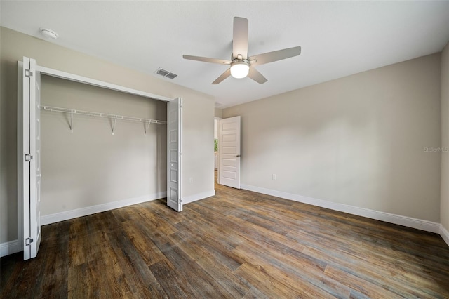 unfurnished bedroom with ceiling fan, dark hardwood / wood-style flooring, and a closet