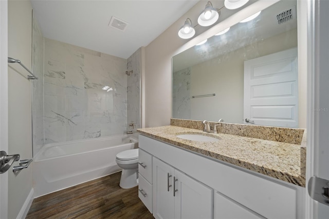 full bathroom featuring vanity, toilet, wood-type flooring, and tiled shower / bath