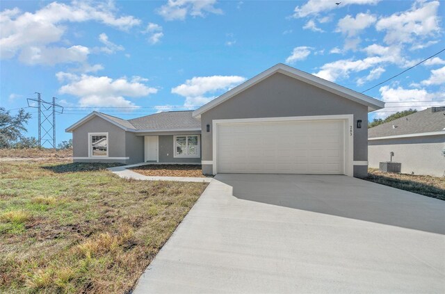 ranch-style house featuring central AC unit, a garage, and a front lawn