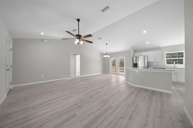 unfurnished living room with plenty of natural light, light hardwood / wood-style floors, and lofted ceiling