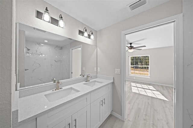 bathroom featuring hardwood / wood-style flooring, vanity, ceiling fan, and tiled shower