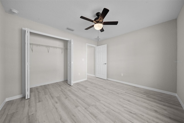 unfurnished bedroom featuring light wood-type flooring, a closet, and ceiling fan