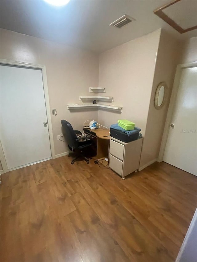 unfurnished office with hardwood / wood-style floors