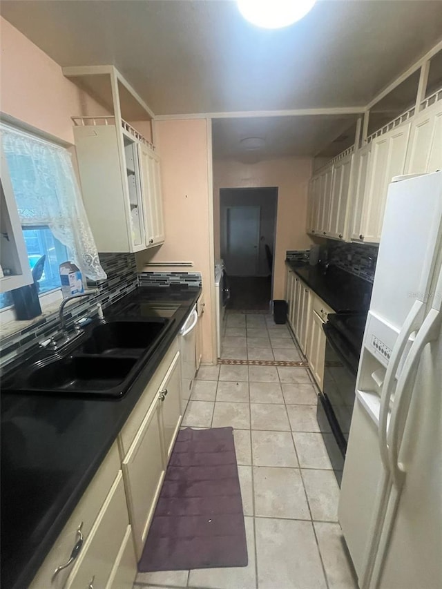 kitchen with tasteful backsplash, sink, light tile patterned floors, black electric range oven, and white fridge with ice dispenser