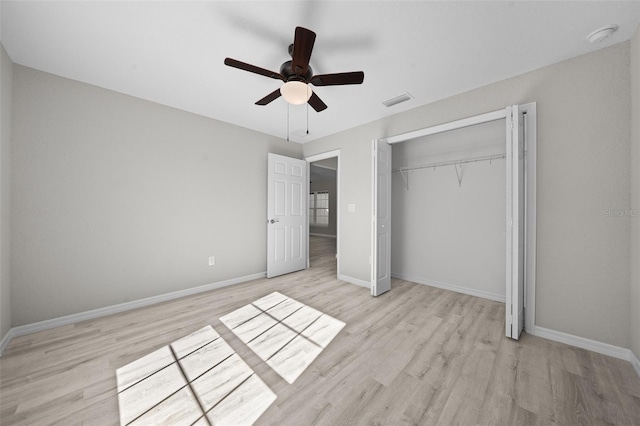 unfurnished bedroom featuring a closet, light hardwood / wood-style flooring, and ceiling fan