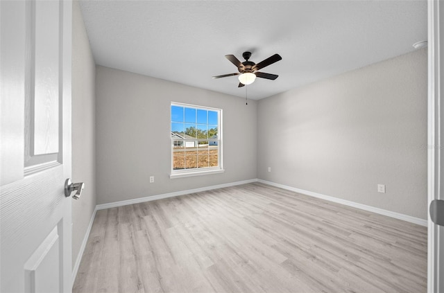 empty room with ceiling fan and light hardwood / wood-style floors