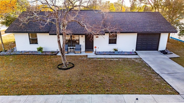 ranch-style house with a porch, a garage, and a front yard