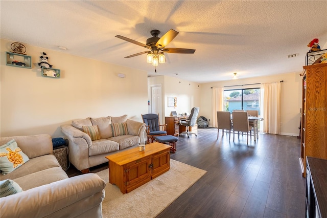 living room with a textured ceiling, ceiling fan, and dark hardwood / wood-style floors