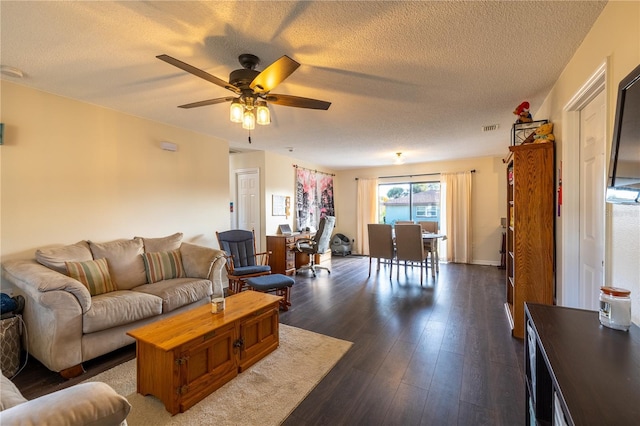 living room with a textured ceiling, dark hardwood / wood-style flooring, and ceiling fan