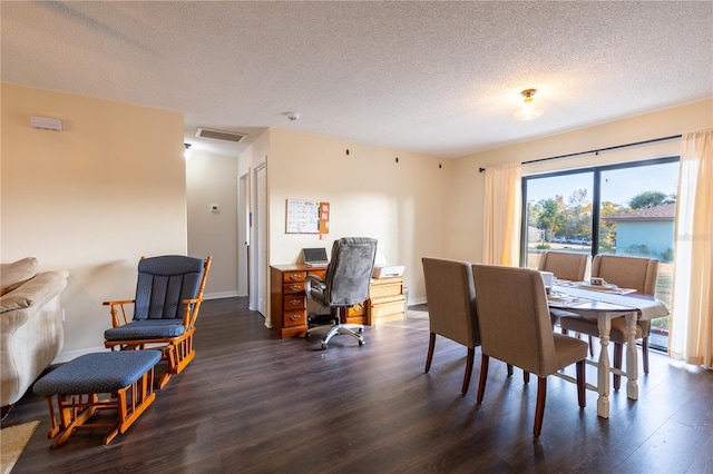 dining room with a textured ceiling and dark wood-type flooring